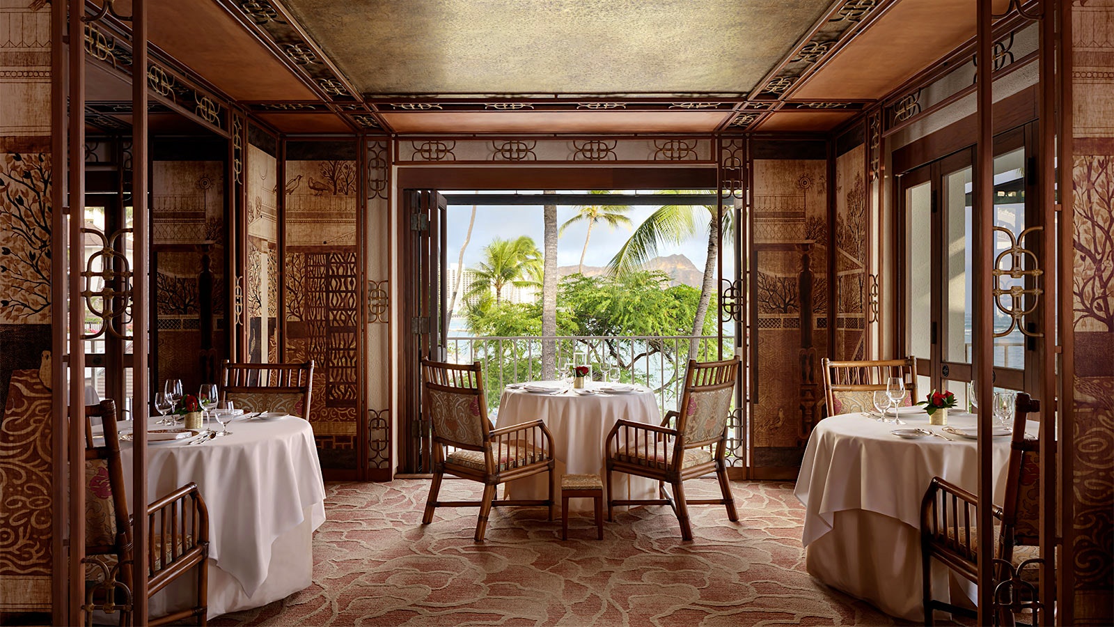 Set tables in the wood-lined dining room of La Mer, with ocean views